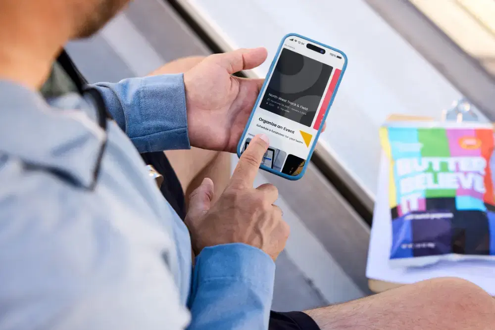 A coach sets up a virtual fundraising event on a smartphone with Double Good.