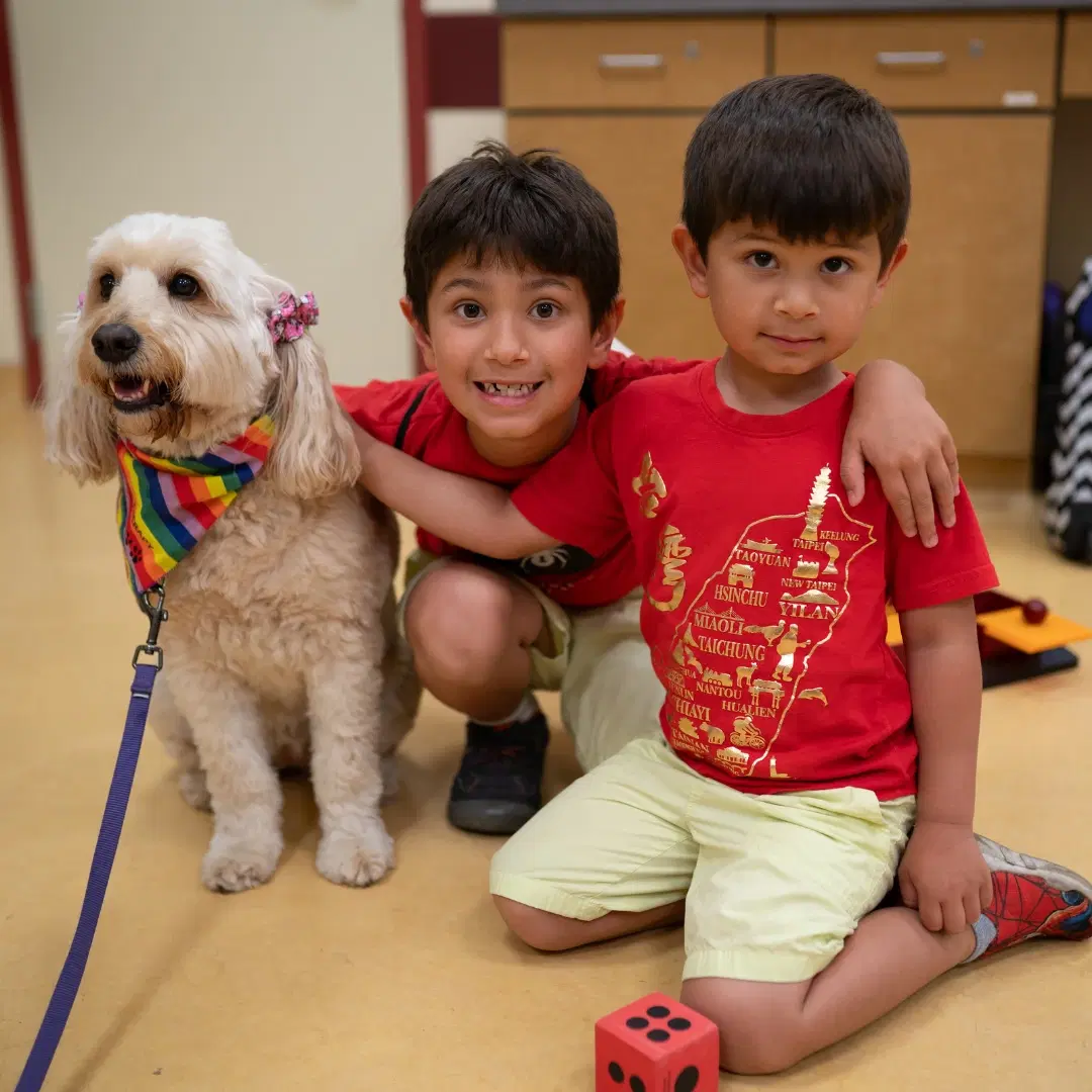 Two boys with a therapy dog at Double Good Days put on by the Double Good Kids Foundation